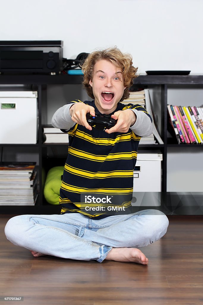 Excitación adolescente jugando un juego, bombas su fist.Winner - Foto de stock de Actividad libre de derechos