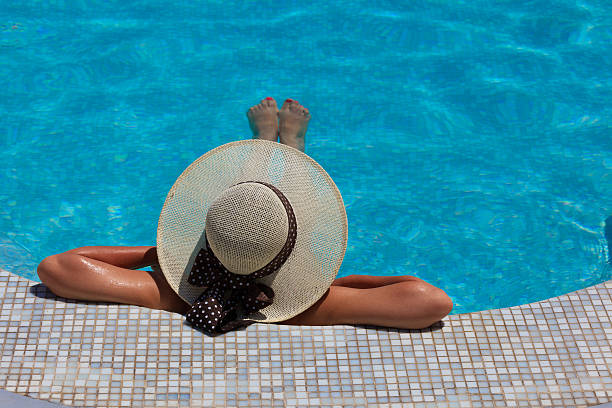 istock Woman in hat relaxing at the pool 471701945
