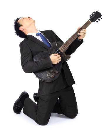 Isolated Asian man with a black electric guitar