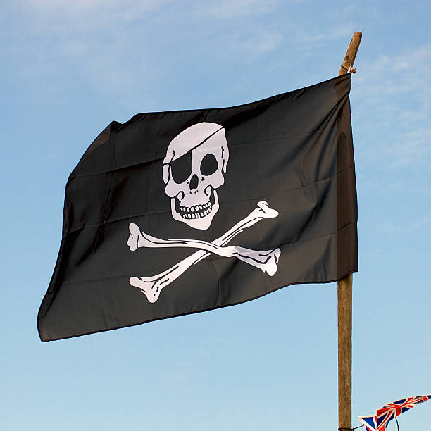 istock Pirate flag in the wind against a blue sky 471702367