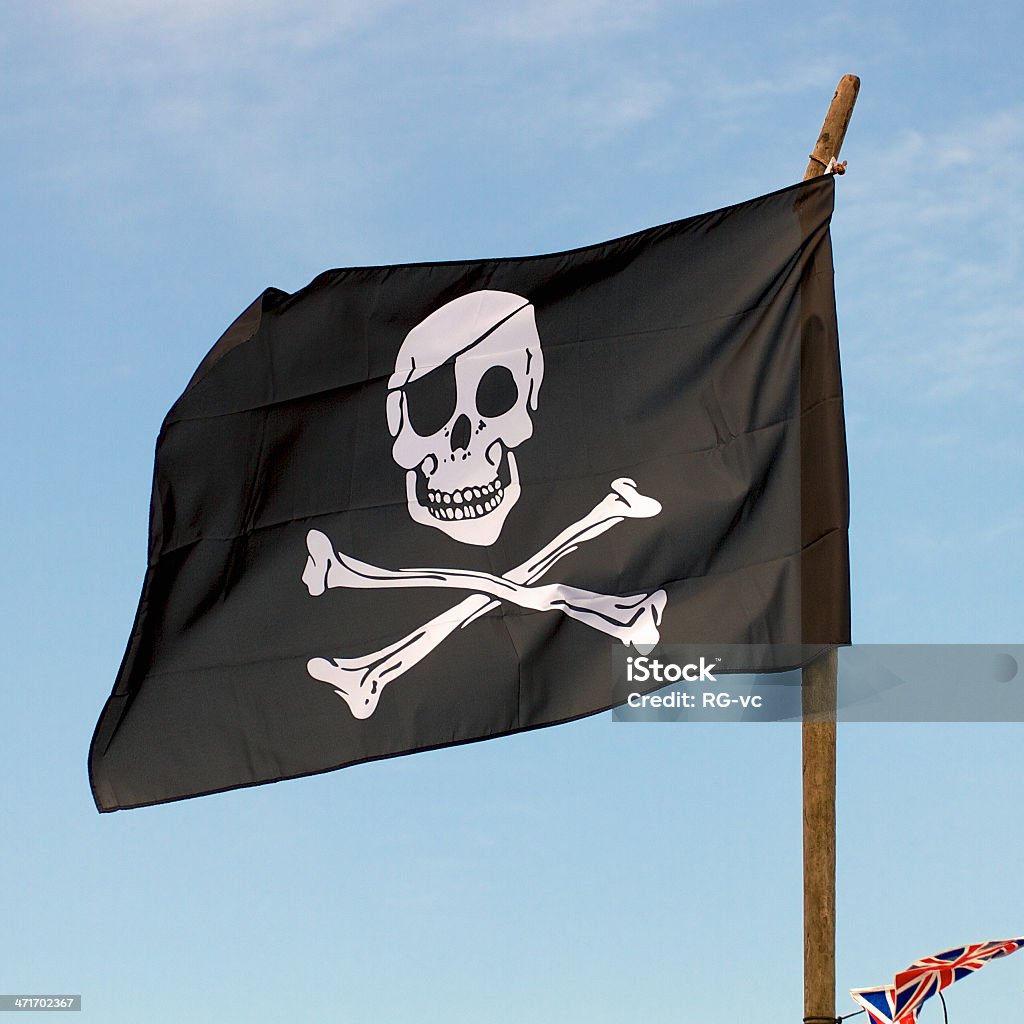 Bandeira de pirata com o vento contra um céu azul - Foto de stock de Acenar royalty-free