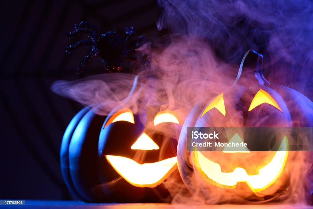 Halloween pumpkin in dark blue with spider web and smoke Halloween pumpkin in dark blue with spider,spider web and smoke American Culture Stock Photo
