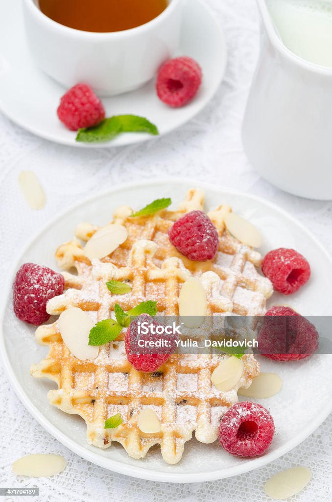 waffles, fresh raspberries and tea for breakfast, top view waffles, fresh raspberries and tea for breakfast, top view vertical Almond Stock Photo