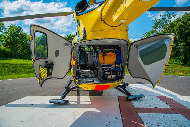 Paramedics helicopter prepared to uploading patient with back dors open