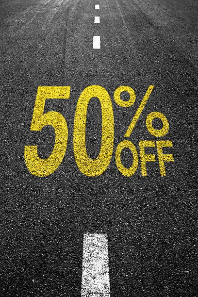 Discount sale sign on the asphalt yellow text: %50 OFF