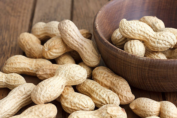 istock Rustic wood bowl of peanuts in shells. 471708072