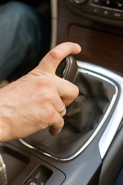 istock Mans hand in suit on gear shift lever in car 471708280
