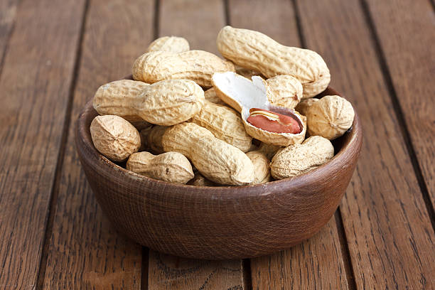 istock Rustic wood bowl of peanuts in shells. 471708508