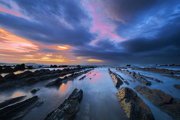 rocks in barrika beach mit dramatischer himmel - long exposure rock cloud sky stock-fotos und bilder