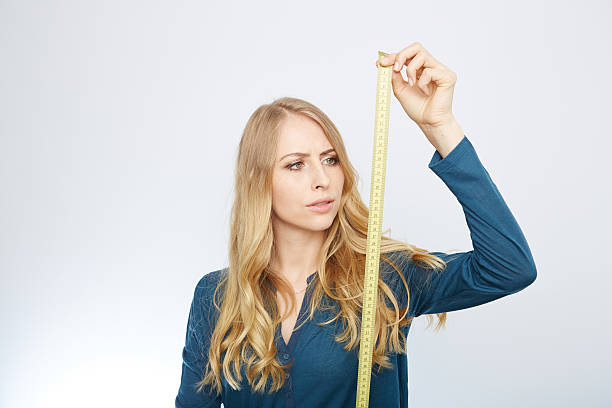 istock young woman with a tape measure 471710104