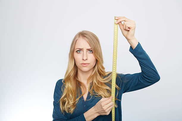 istock young woman with a tape measure 471710128