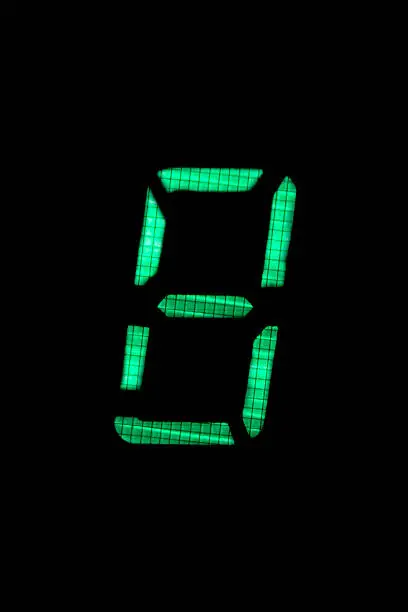 Photo of digital number eight in green on black background