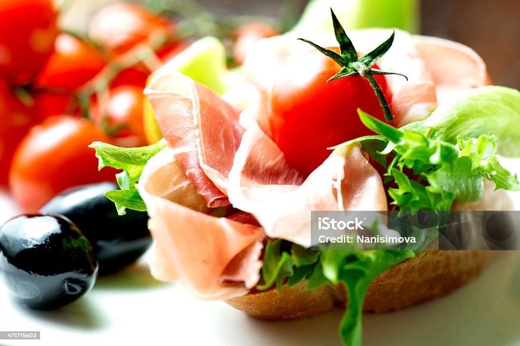 Sándwiches prosciutto en placa con tomate - Foto de stock de Aceituna libre de derechos