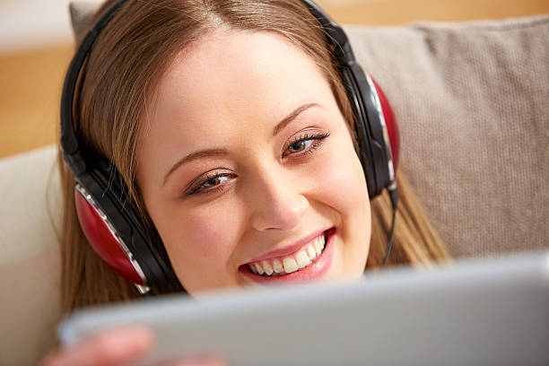 istock Young girl wearing headphones looking at tablet pc 471716935