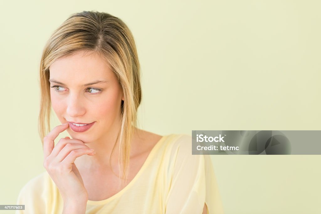 Hermosa mujer mirando lejos con la mano en la barbilla - Foto de stock de 20 a 29 años libre de derechos