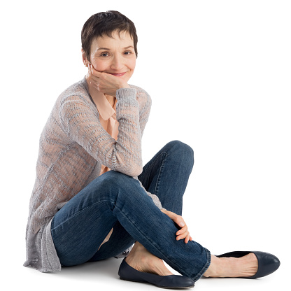 Portrait of happy mature woman with hand on chin sitting over white background