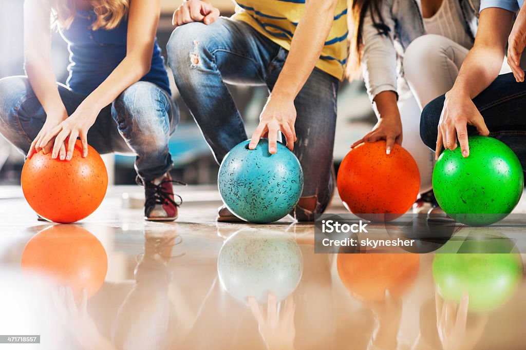 Unrecognizable people with bowling balls. Four unrecognizable people crouching with bowling balls.    Ten Pin Bowling Stock Photo