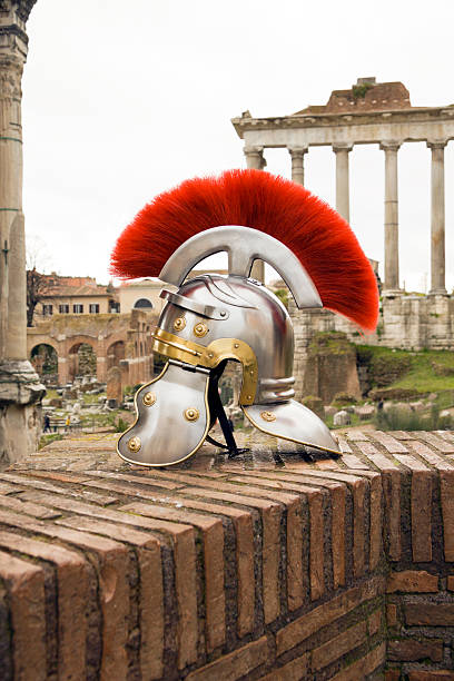 roman soldier capacete em frente à "fori imperiali", roma. - caesar emperor rome stone - fotografias e filmes do acervo