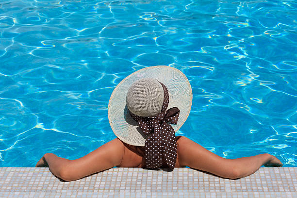 istock Woman in hat relaxing at the pool 471719647