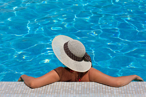 istock Woman in hat relaxing at the pool 471719685
