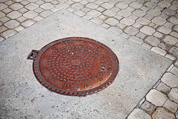 istock Old rusted sewer manhole on the cobblestone road 471720255