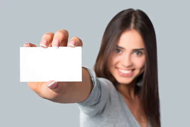 Close-up of a blank business card in young beautiful woman hand. You can put your text.