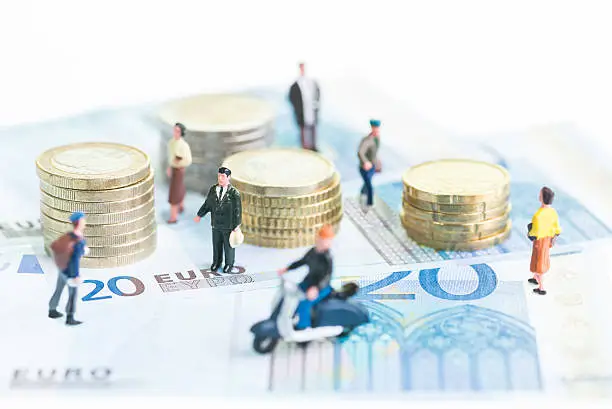 Miniature people on 20 Euro banknotes and coins close-up