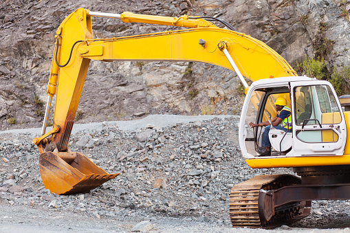 african road construction worker operating excavator on construction site