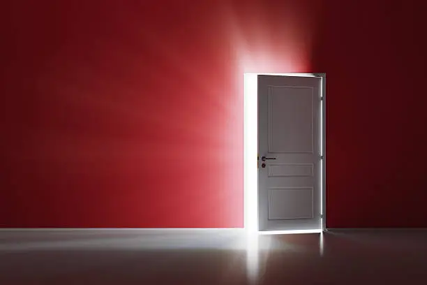 Photo of Open white door on red wall