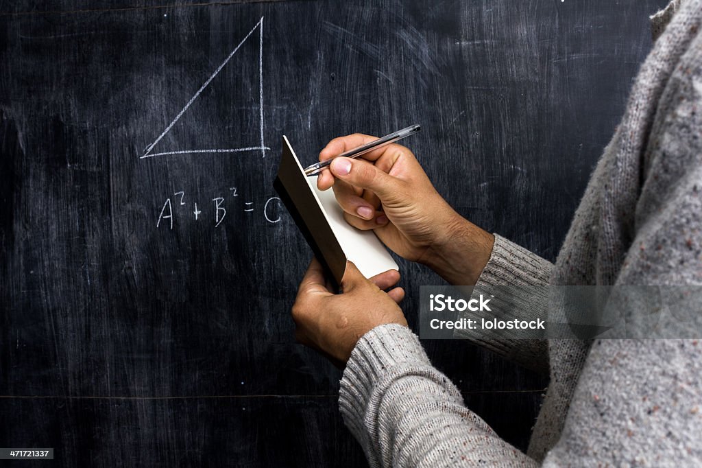 Man taking notes of math theorem on blackboard Pythagoras Stock Photo