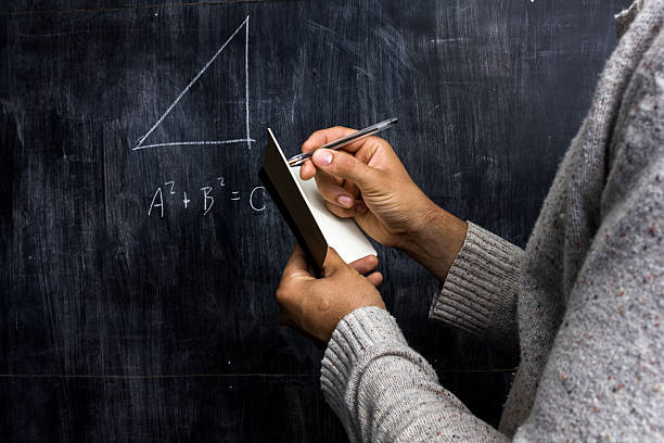 Man taking notes of math theorem on blackboard Man taking notes of math theorem on blackboard pythagoras stock pictures, royalty-free photos & images
