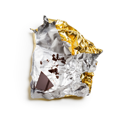 Piece of chocolate bar on wrapper with clipping path