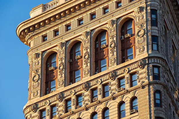 Architectural detail of the base side of the Flatiron Building, from 22nd Street. It is an example of Beaux-Arts architecture and was one of the tallest skyscrapers in New York City when  completed in 1902. The facades of the upper floors are intricately decorated with terra cotta ornaments and the building is crowned by rounded cornices.