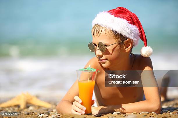 Menino Em Santa Chapéu De Natal Na Praia - Fotografias de stock e mais imagens de Ao Ar Livre - Ao Ar Livre, Areia, Atividade Recreativa