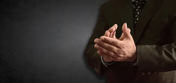 Photo of Businessman clapping - blackboad in background