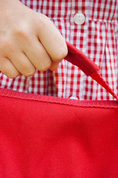 istock Back to school child hand holding red bag 471726485