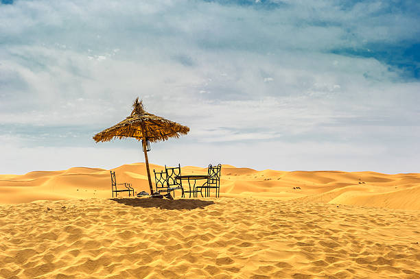 istock Sun umbrella and chairs in desert 471726785