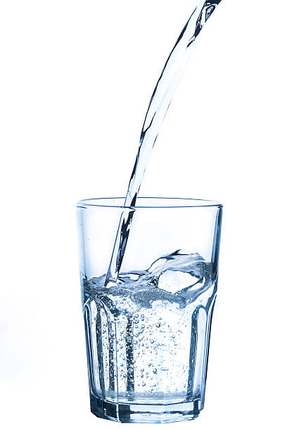 istock Pouring water into glass on white background 471727880