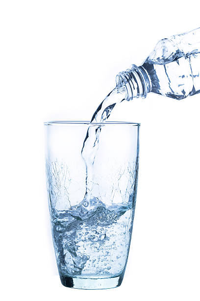 istock Pouring water into glass on white background 471727904