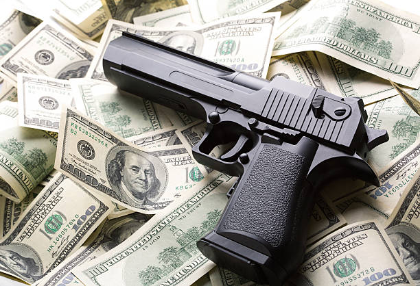 haufen geld und pistole - guns and money stock-fotos und bilder