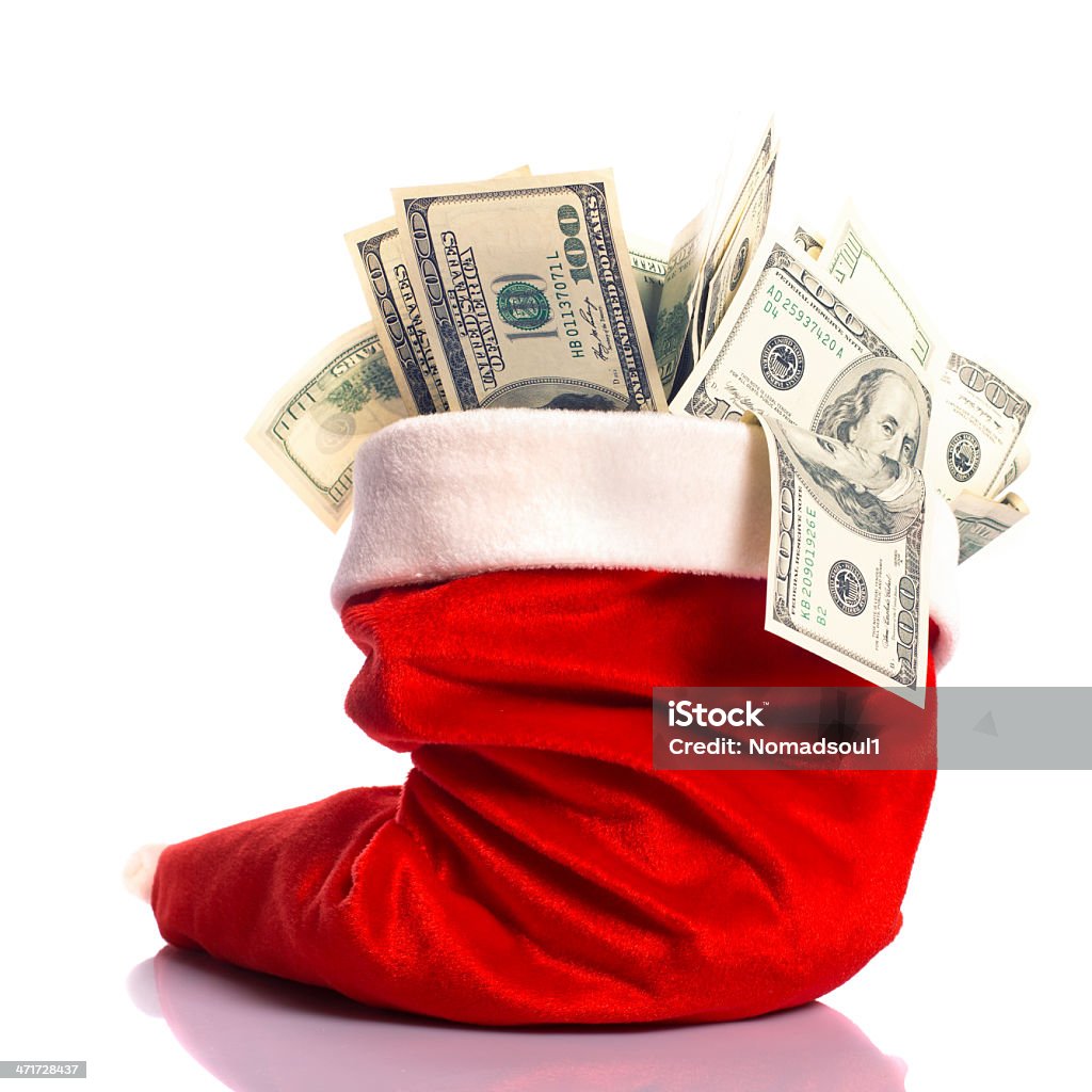 Christmas hat full of money Christmas hat full of $100 dollar bill isolated on white Christmas Stock Photo