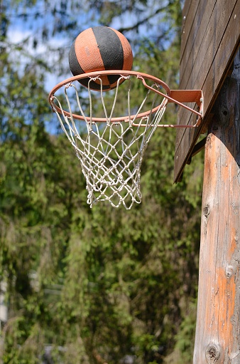 basketball going through an outdoor basketball hoop 