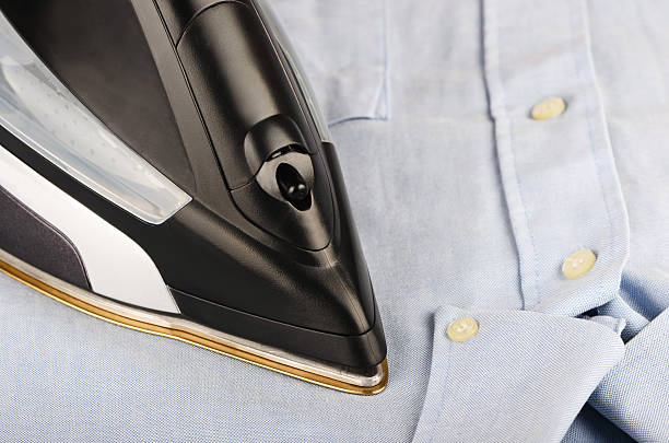 istock Steam iron on a gray shirt 471729797
