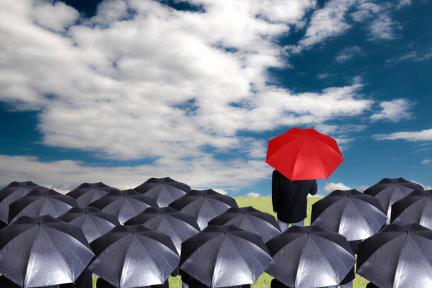 istock Leader holding red umbrella for show different think 471732109