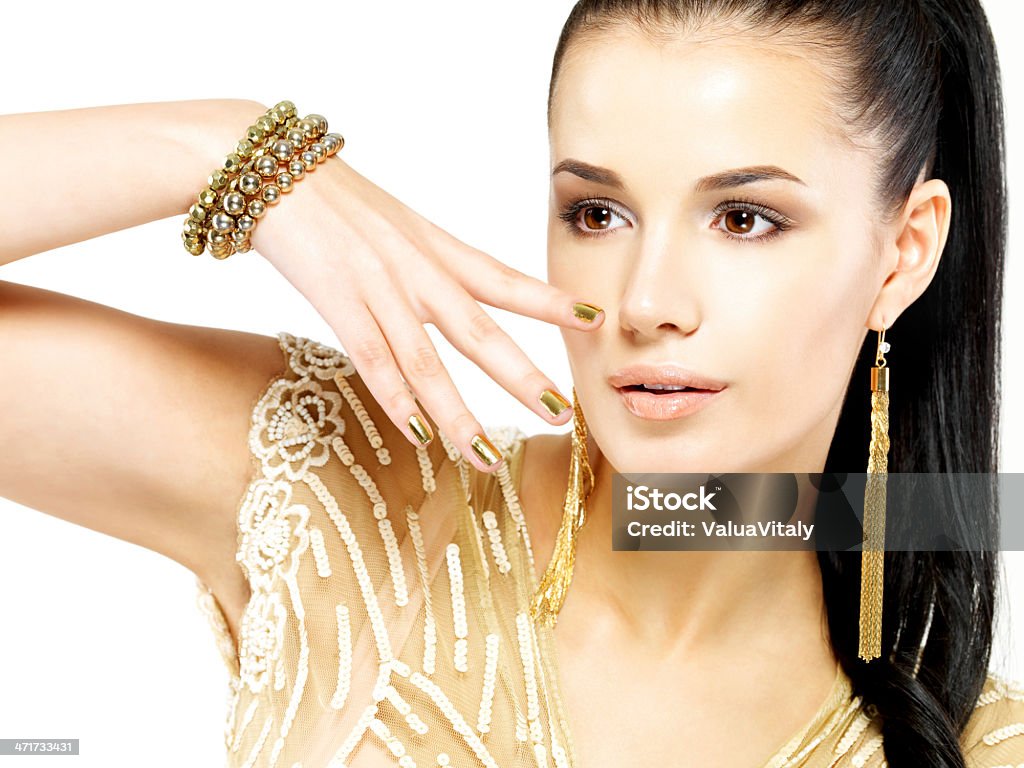Femme avec clous or et de magnifiques bijoux en or - Photo de A la mode libre de droits