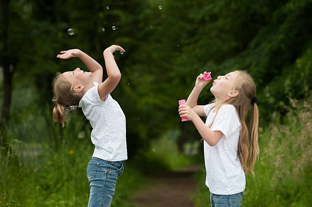 istock little girl blowing soap bubbles 471734595