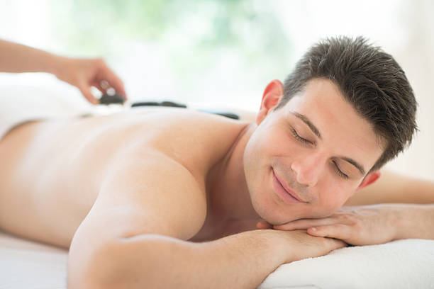 man 受信スパのホットストーンセラピー - lastone therapy spa treatment massaging massage therapist ストックフォトと画像