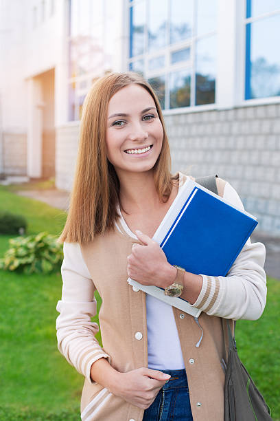 istock Student standing with books and smiling at camera 471736028