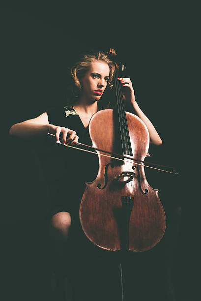 istock Attractive young woman playing the cello 471736536