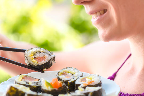 young woman eating sushi